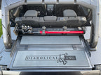 Image of a Jeep Wrangler JKU with a Diabolical, Inc. Slipstream security enclosure and foam deck pads with the Rail Rack accessory mount installed with a HiLift Jack.