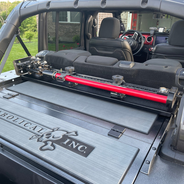 Image of a Jeep Wrangler JKU with a Diabolical, Inc. Slipstream security enclosure and foam deck pads with the Rail Rack accessory mount installed with a HiLift Jack.